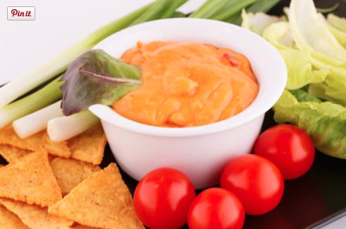 Spicy Peanut Dip with turmeric in a bowl with fresh veggies