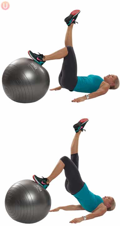 Chris Freytag performing lift and lower with one leg on stability ball wearing black yoga pants and blue top