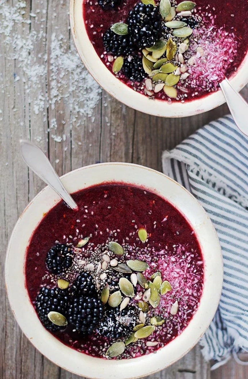 The blackberry coconut smoothie bowl topped with blackberries, pumpkin seeds, and chia seeds.