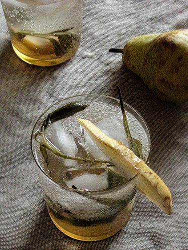 A pear and sage non-alcoholic sparkler drink in two glasses with pear garnish