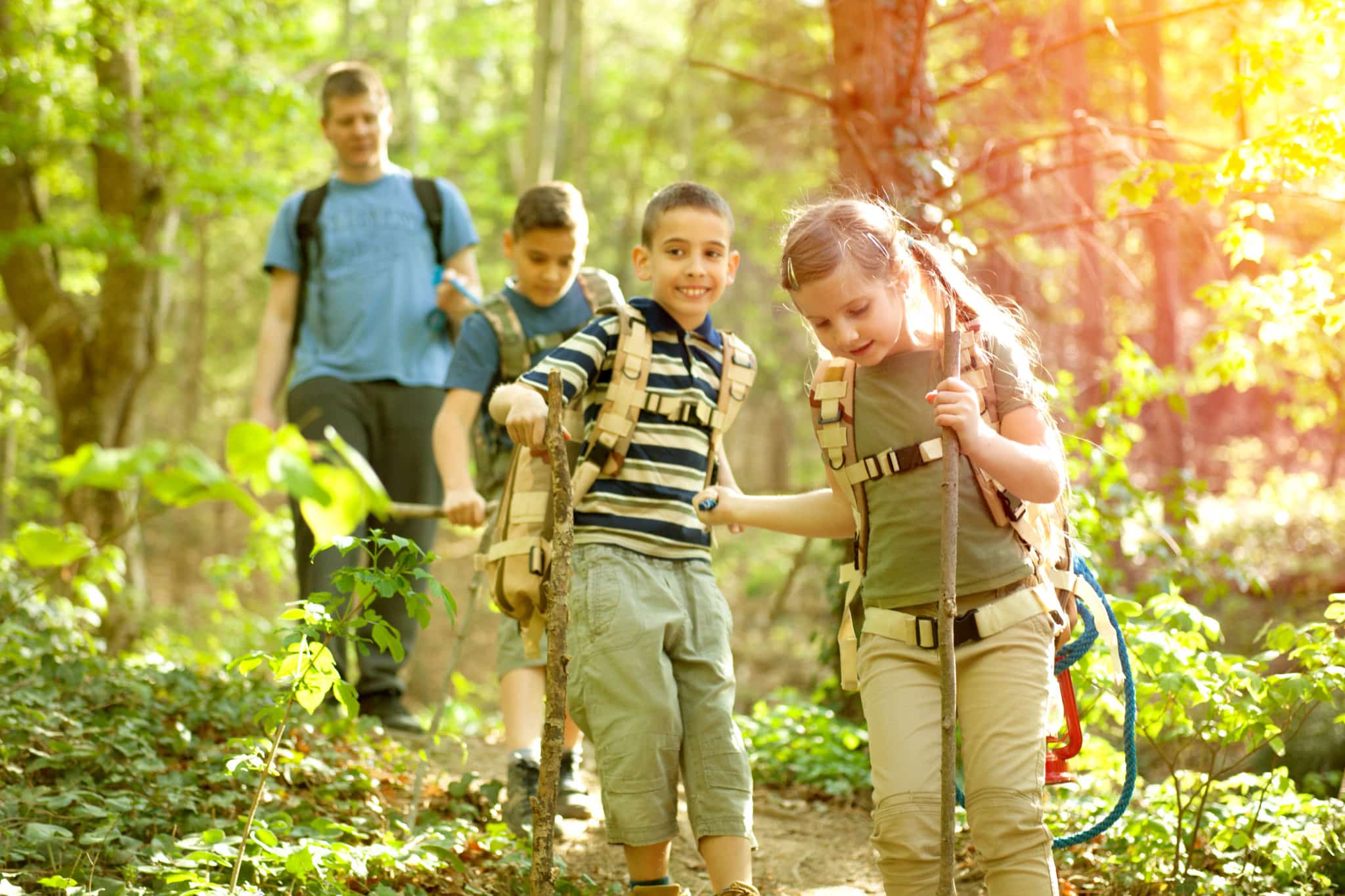 Kids hiking outdoors surrounded by trees