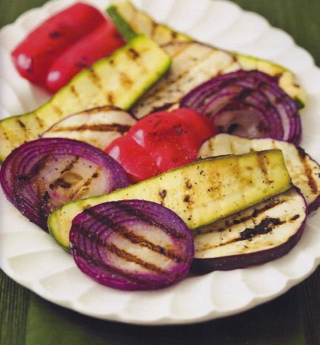 a white plate filled with grilled, onion, zucchini. and peppers