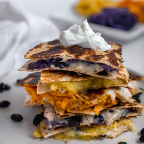 Chicken quesadilla stack with acorn squash, sweet potato and black bean filling on plate