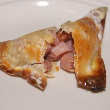 Ham and Cheese Mini Pocket cut in half on a white plate.