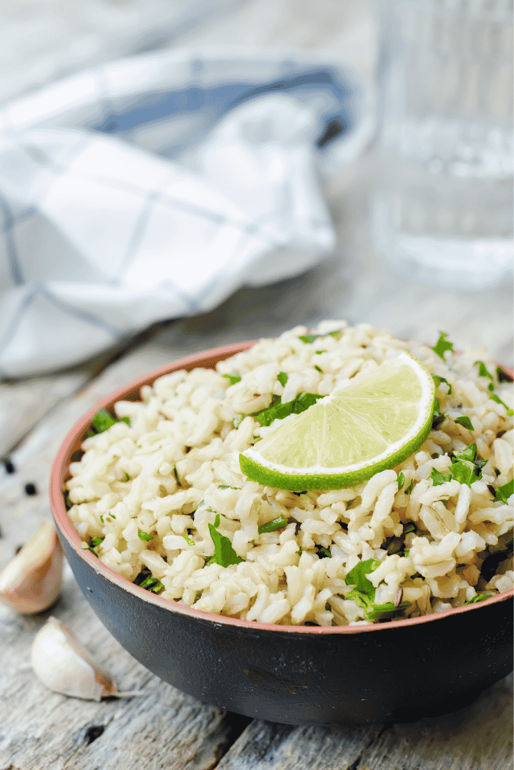 Cilantro lime rice in a bowl with a lime wedge