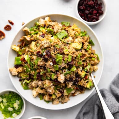 wild rice salad with chicken prepared on white counter with extra toppings