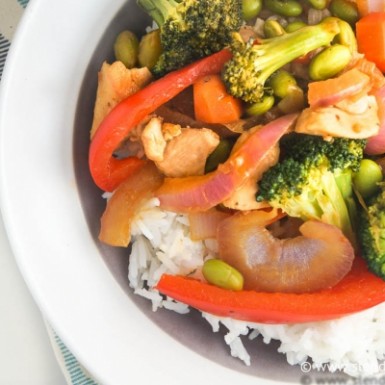 Spicy Peanut Chicken with broccoli, peppers and onions on a bed of rice