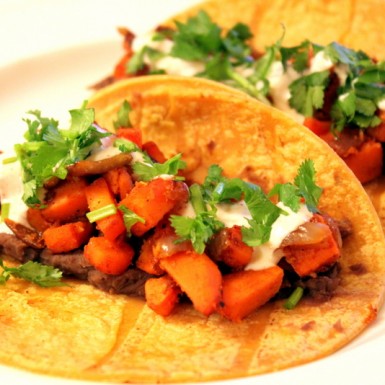 Sweet Potato Tacos With A Spicy Yogurt Sauce on a white plate.