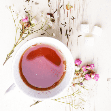 A cup of tea with various florals sitting on a white table