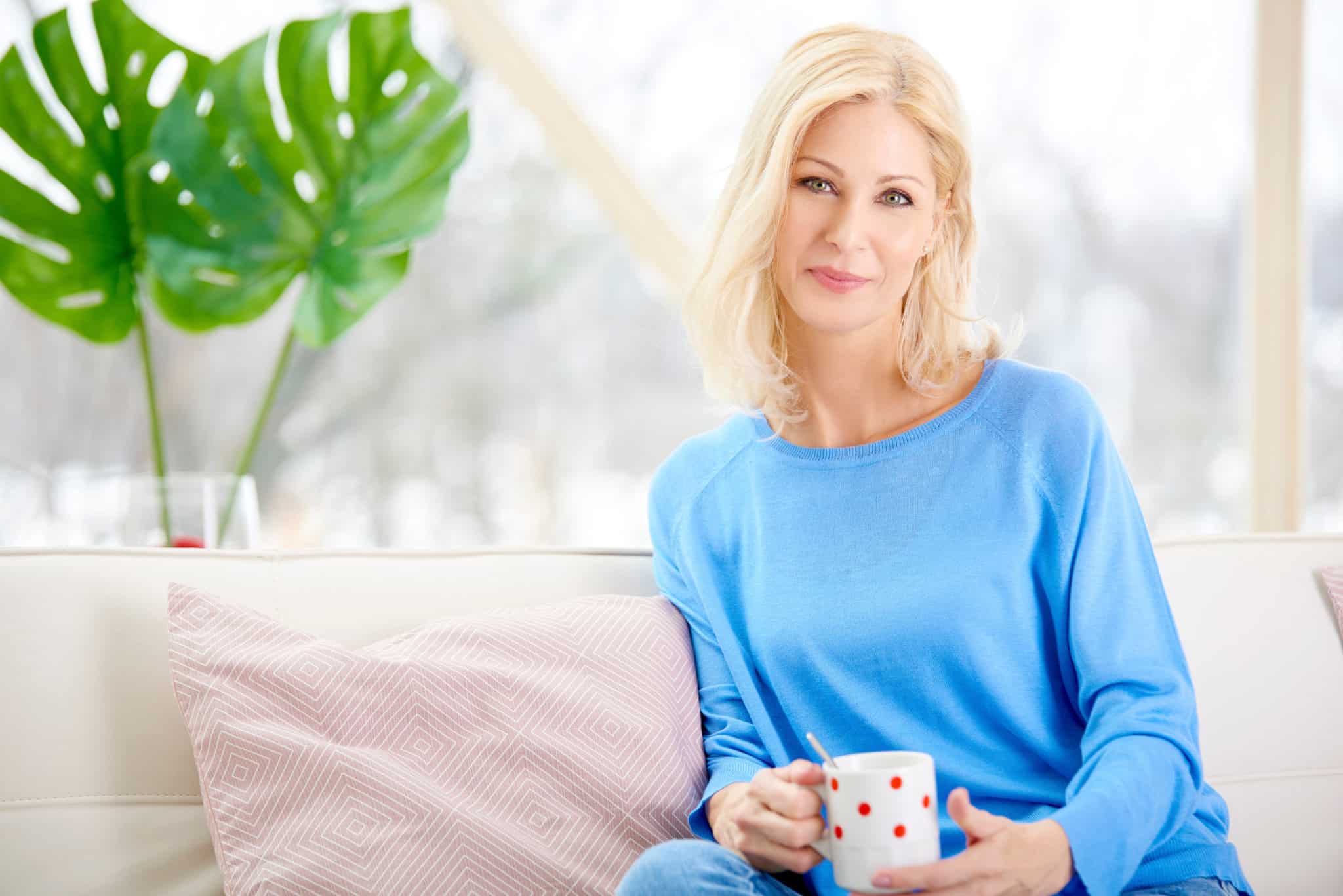 Middle aged woman holding a cup of tea for its health benefits