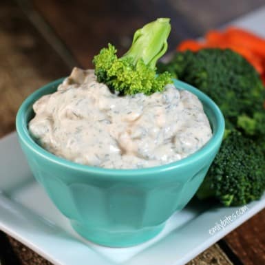 Creamy Dill Dip in a blue bowl with broccoli florets