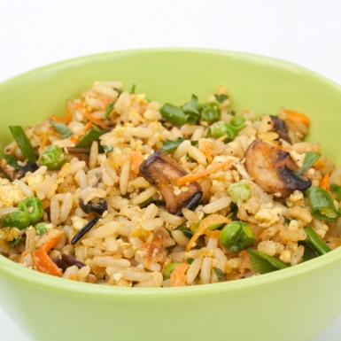a green bowl filled with vegetable fried rice