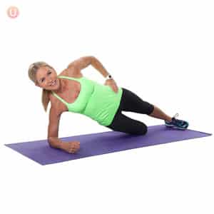 Chris Freytag Demonstrating Modified Forearm Side Plank on a purple yoga mat