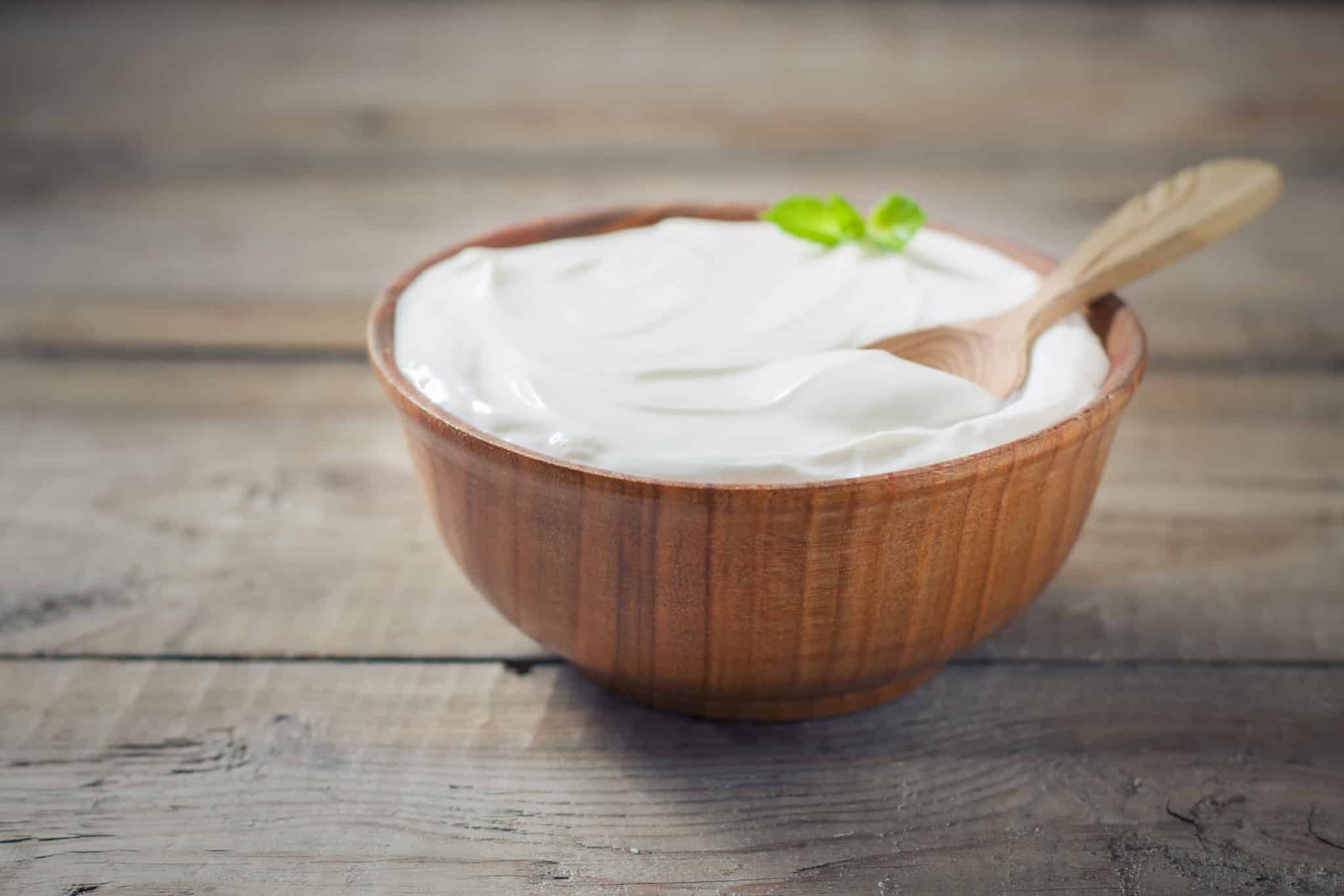Wooden bowl of greek yogurt with spoon