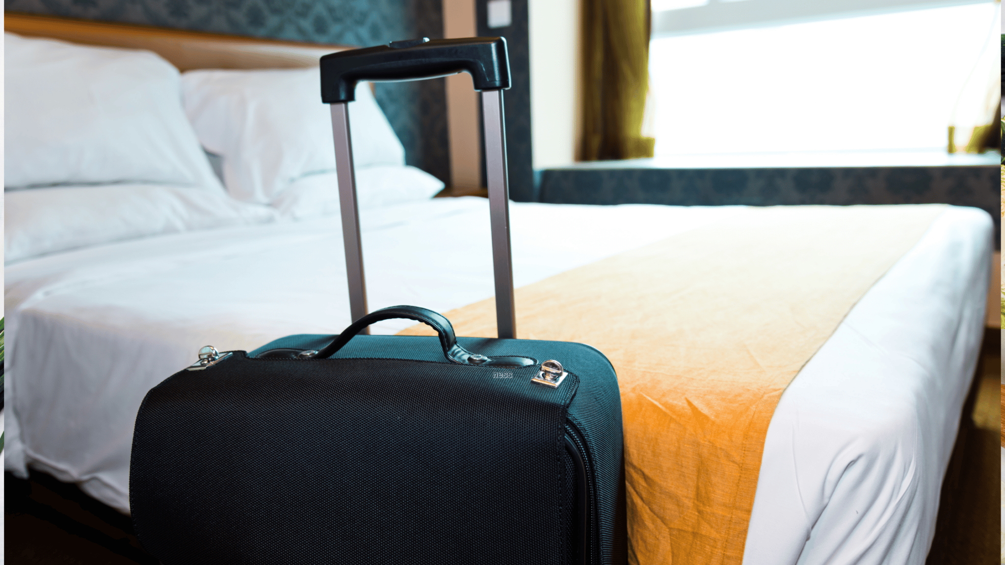 suitcase by a hotel bed