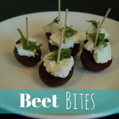 a plate with baby beets sliced in half. Topped with goat cheese fresh basil.