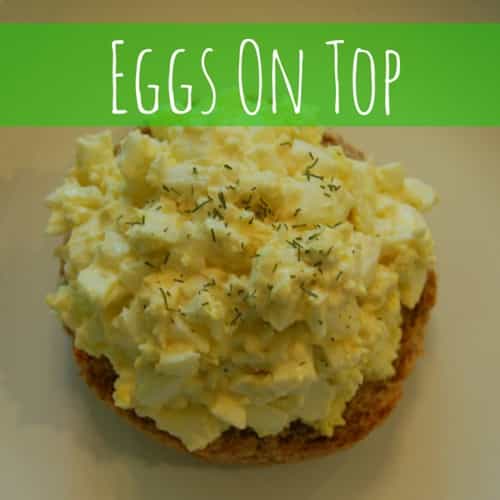 An english muffin topped with egg salad and sprinkled with dill