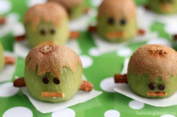 Frankenstein Kiwis which are kiwis that are decorated like Frankenstein on a green and white polka dot napkin.