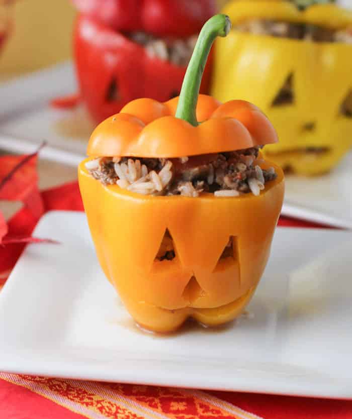 Healthy halloween recipe of stuffed peppers looking like jack-o-lanterns