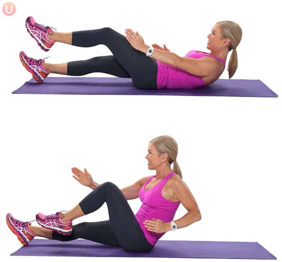 Chris Freytag demonstrating a sprinter sit-up exercise in pink tank top and black yoga pants.