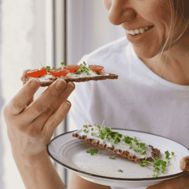 woman smile as she eats healthy snack
