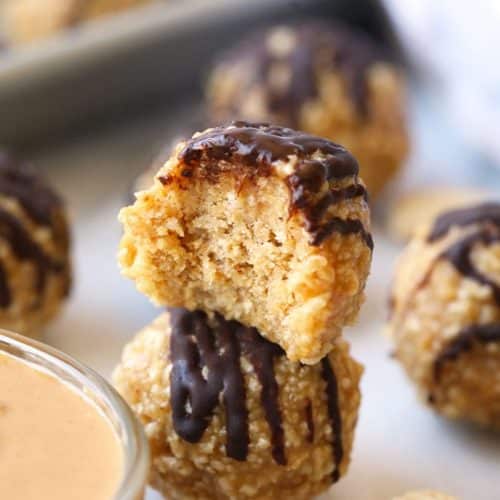 Peanut butter crunch balls with chocolate drizzle sitting on sheet pan