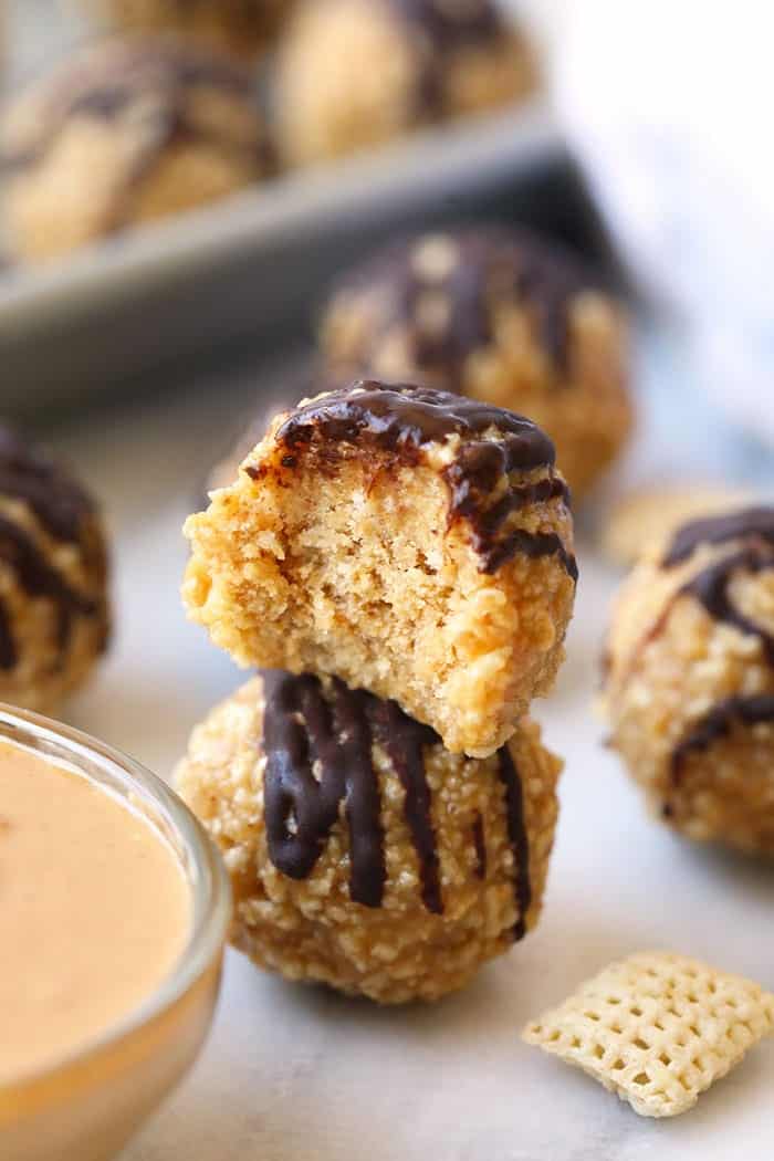 Peanut butter crunch balls with chocolate drizzle sitting on sheet pan