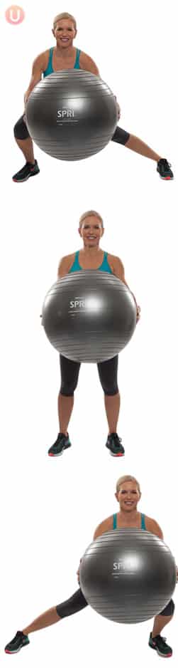 Chris Freytag demonstrating a side to side lunge holding a stability ball wearing black yoga pants and a blue top 