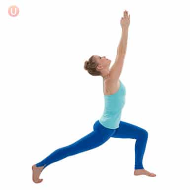 Chloe Freytag demonstrating crescent lunge in a blue tank top and yoga pants