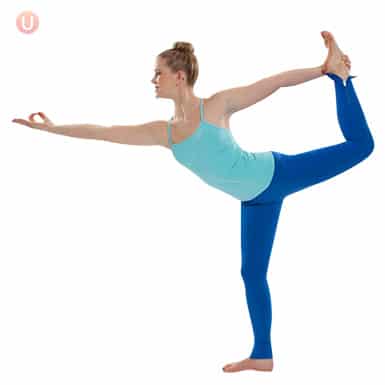 Chloe Freytag demonstrating Dancer pose in a blue tank top and yoga pants.