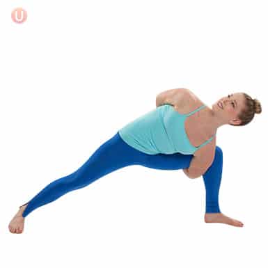 Chloe Freytag demonstrating how to do an extended side angle with a bind in a blue tank top and yoga pants