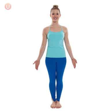 Chloe Freytag demonstrating Mountain Pose in a blue tank top and yoga pants
