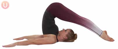 Chloe Freytag Demonstrating Plough Pose in a black tank top and yoga pants