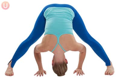 Chloe Freytag demonstrating Standing Straddle Splits in a blue tank top and yoga pants