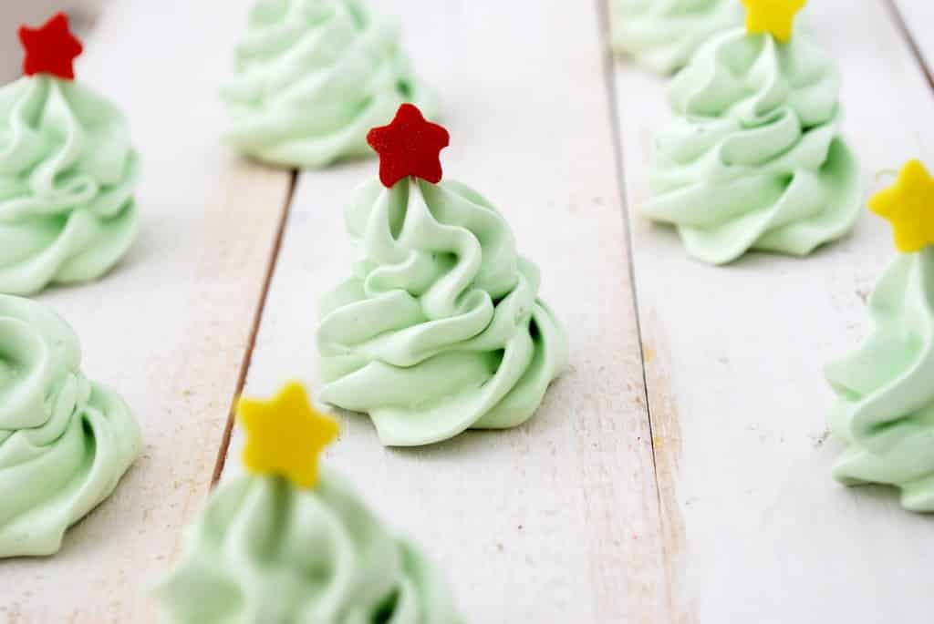 Christmas Tree Meringue Cookies on a white wooden table.
