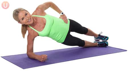 Chris Freytag demonstrating forearm side plank in a green tank top