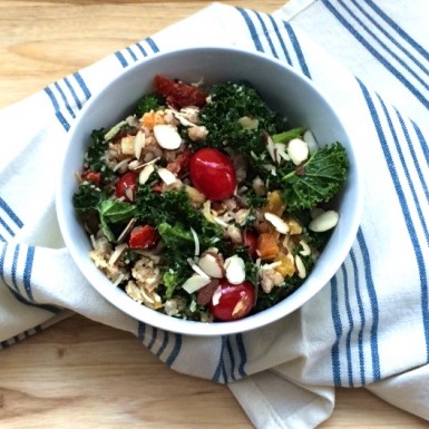 a white bowl filled with a kale, broccoli, and farro salad