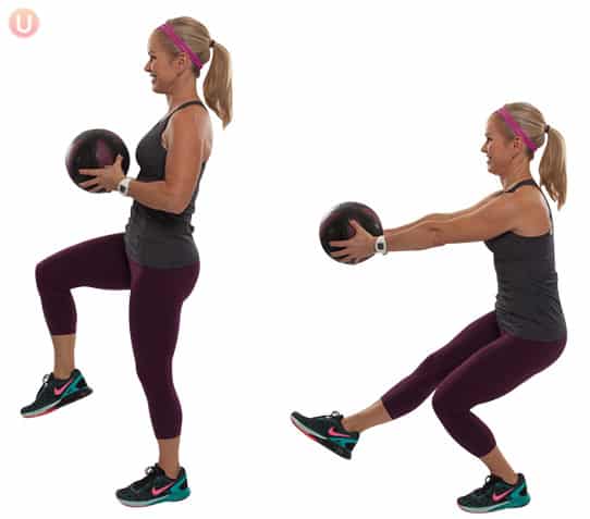 Chris Freytag demonstrating a medicine ball pistol squat wearing a black top and workout pants.