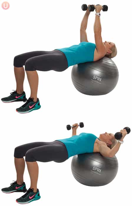 Chris Freytag demonstrating Stability Ball Chest Fly in a blue tank top on a silver stability ball