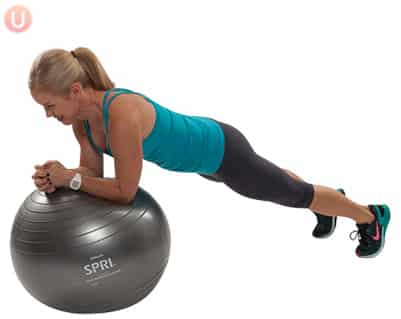 Chris Freytag demonstrating Stability Ball Forearm Plank in a blue tank top on a silver stability ball