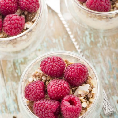 3 clear bowls of Vanilla Raspberry Overnight Oats on a wooden table.