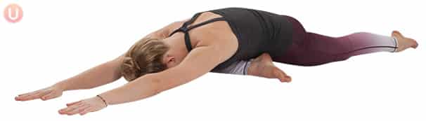Chloe Freytag demonstrating Sleeping Pigeon in a black tank top and yoga pants