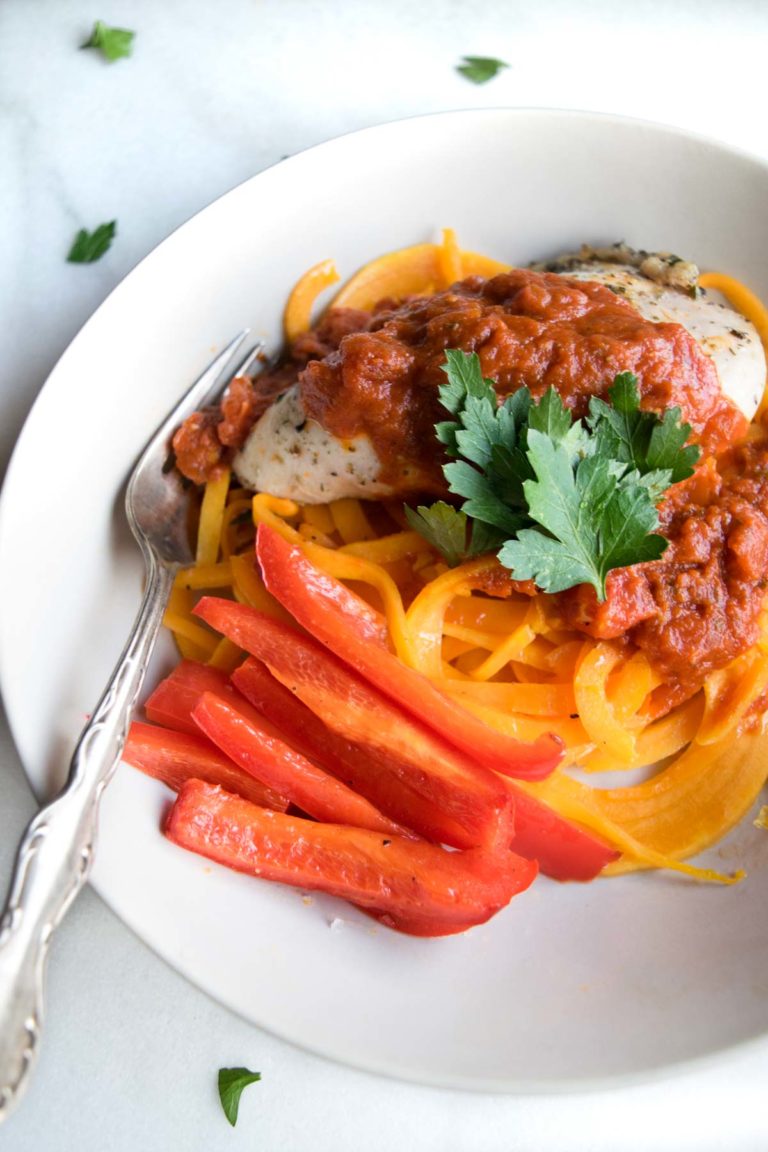 Butternut squash noodles with chicken and red pepper in a cream colored bowl