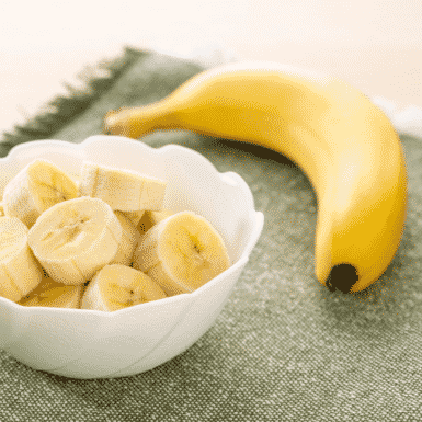 bananas on a table and in a white bowl
