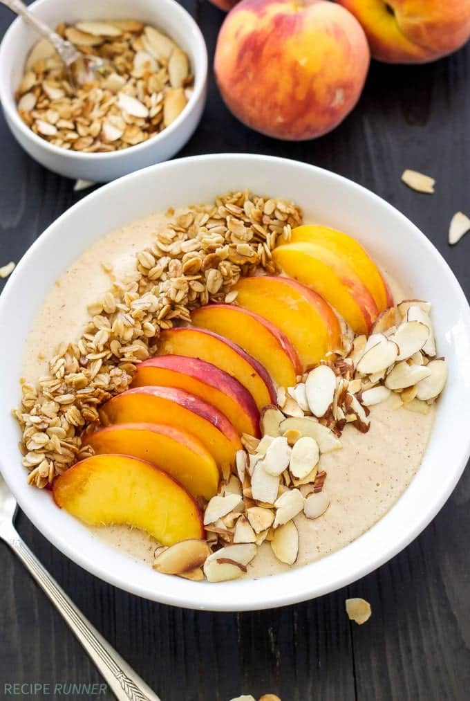 The peach pie smoothie bowl topped with sliced peaches, granola, and toasted almonds.