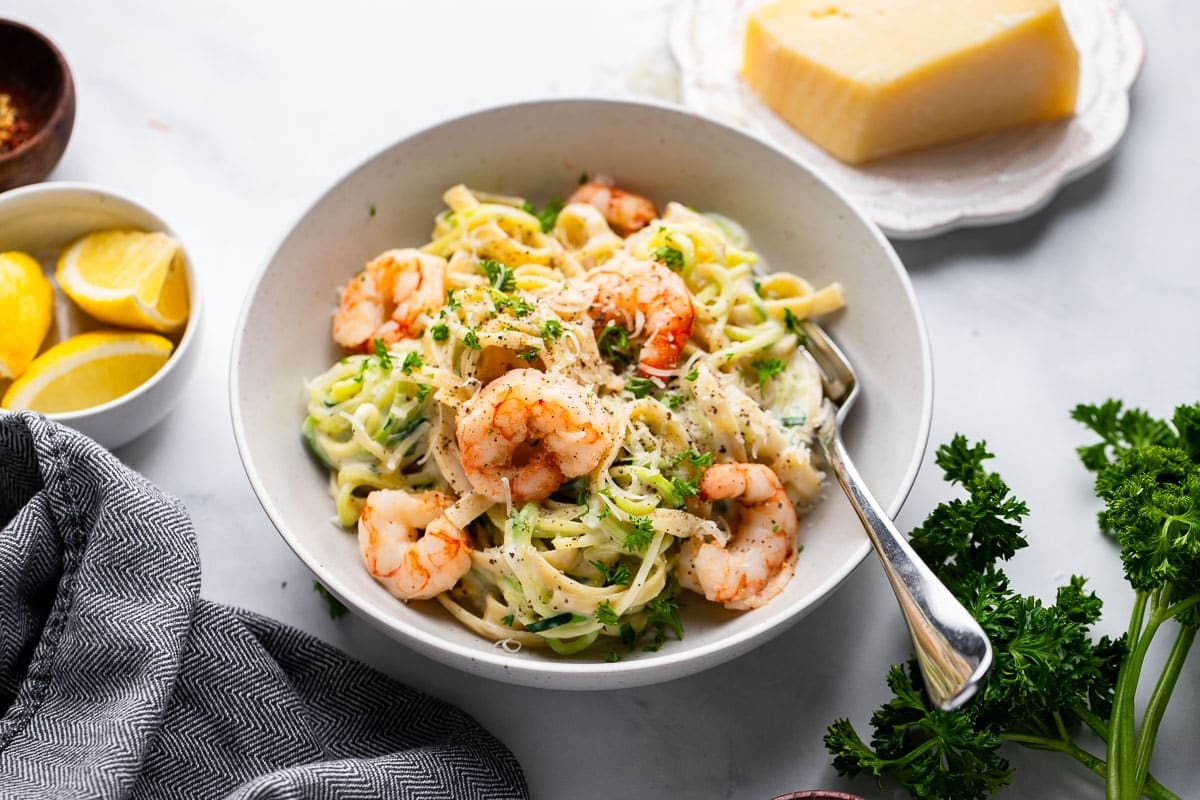 prepared serving of healthy shrimp alfredo in bowl on white counter
