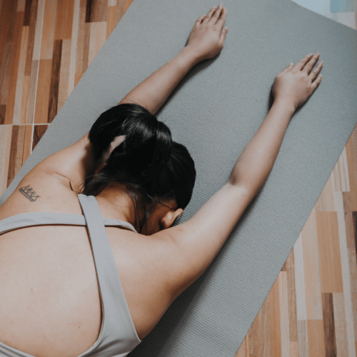 woman facing down on yoga mat