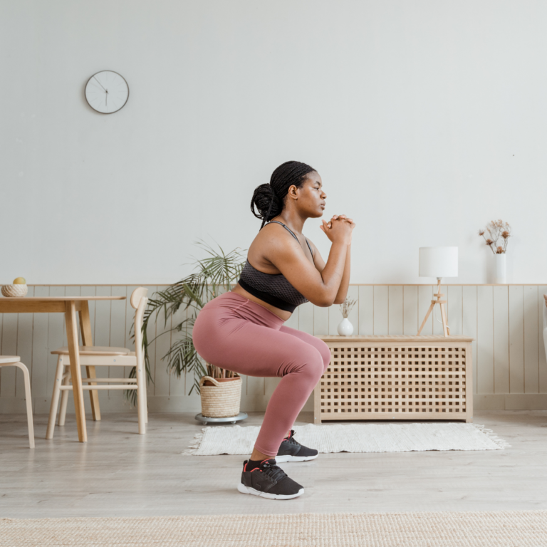 woman successful  pinkish  legging doing a workout squat successful  her home