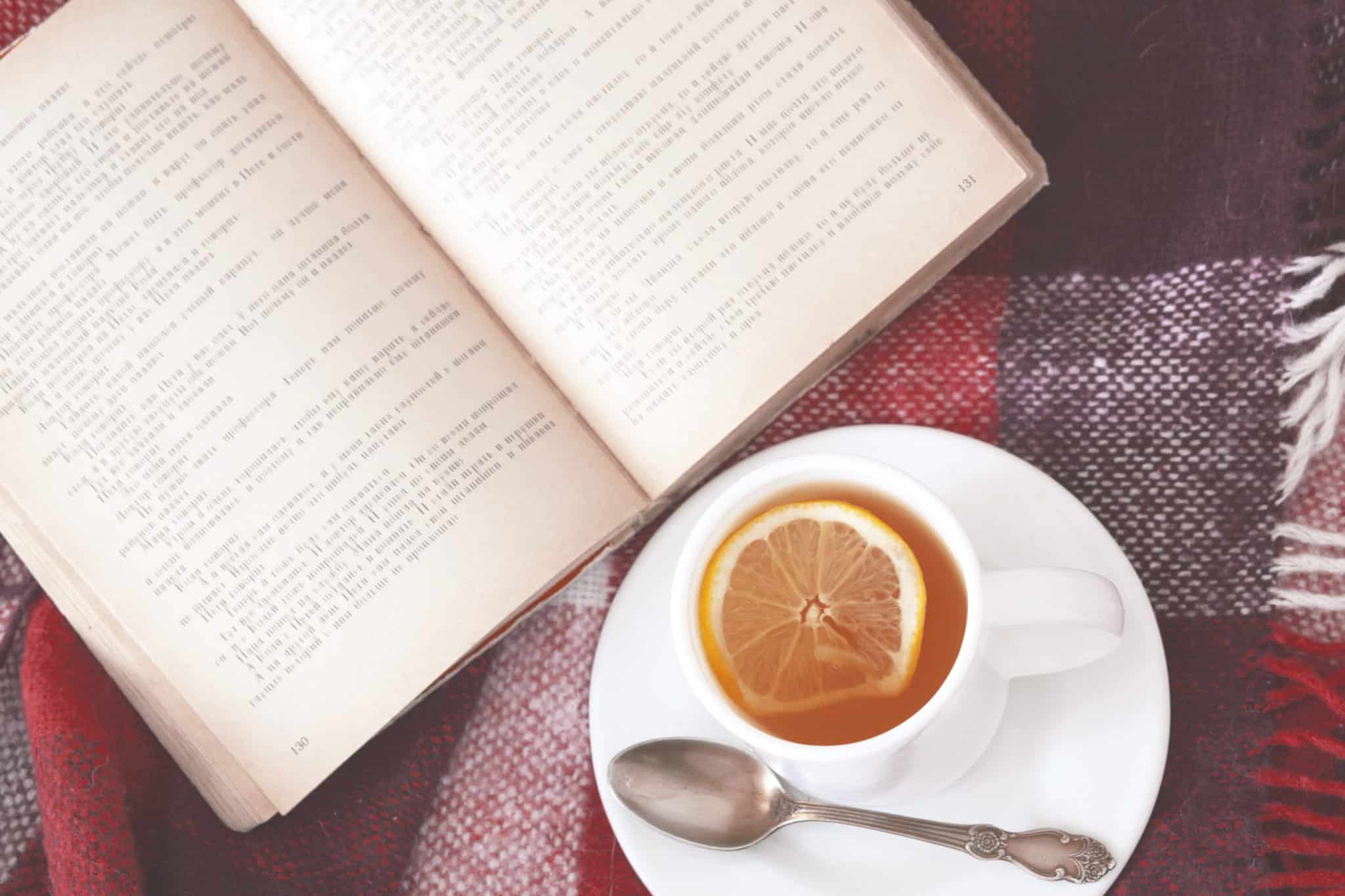 An open journal next to a cup of tea.