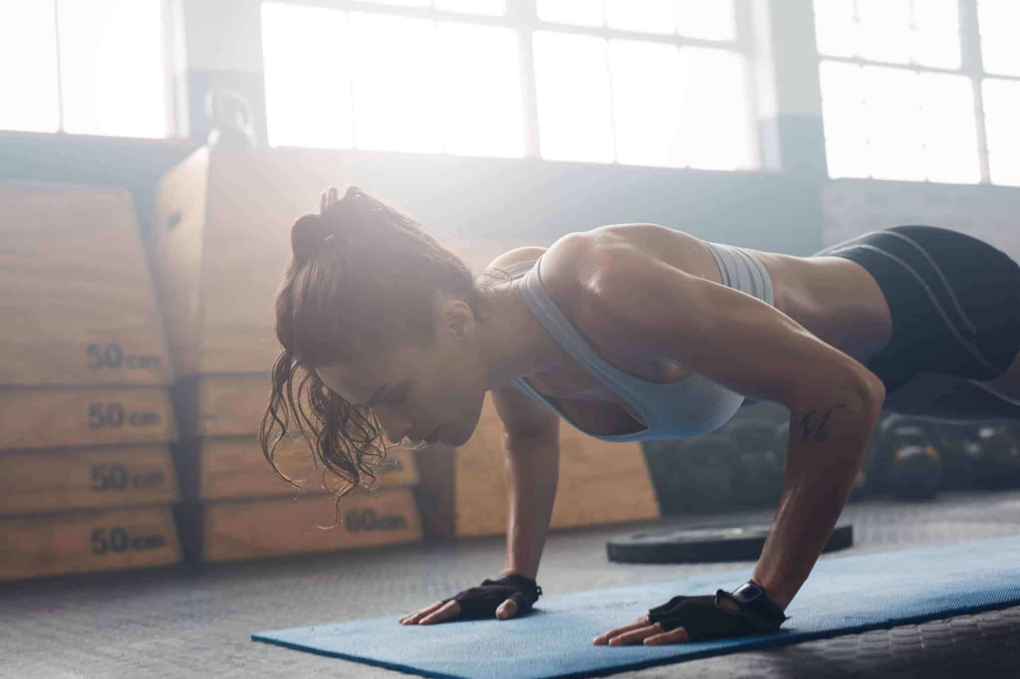 Woman doing a push up in a gym